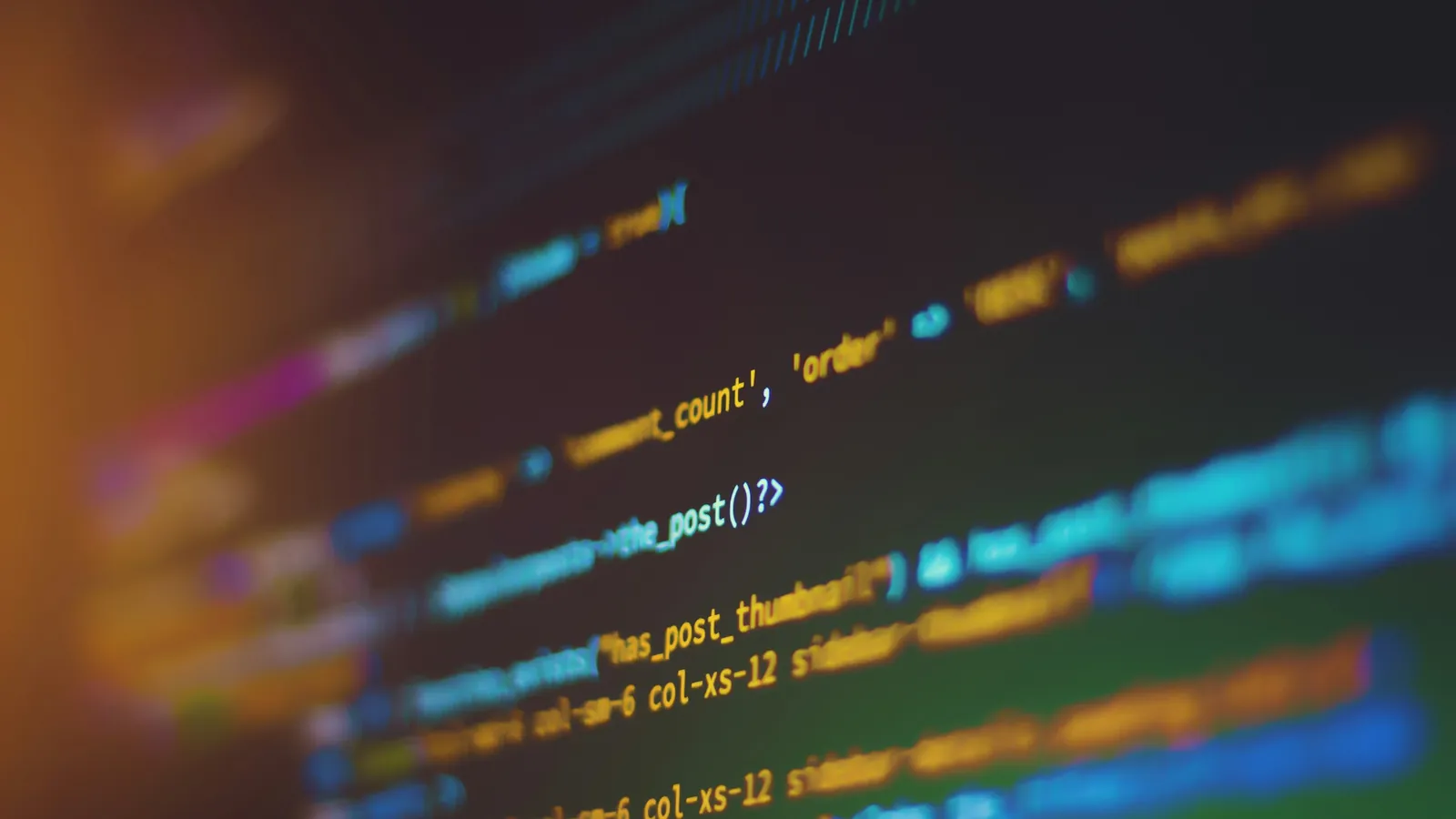 Close-up of colourful source code on a dark computer screen