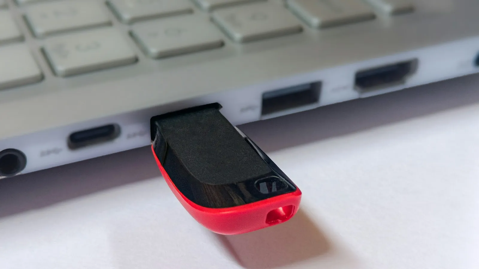 Red USB flash drive plugged into a silver laptop